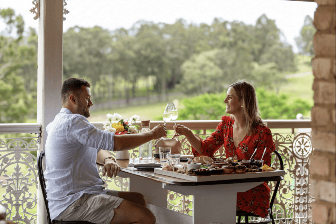 Couple dines on balcony at Restaurant Kawul, an Indigenous restaurant in Australia. 